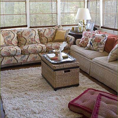 Кушетки are against the windows of the living room while a white, plush carpet rug is laid in the center of the room--which creates more space for children to play in the living room.