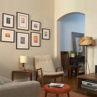 生活 room with mid-century furniture, lamps and arm chair with framed art on the light cream walls