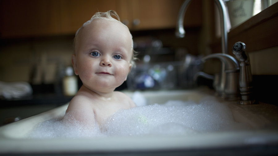 бебе Boy Taking Bath in Sink