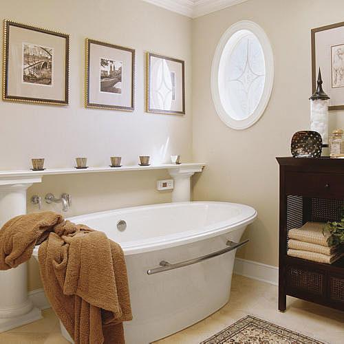 бяло, freestanding tub with a classic white shelf held up by neoclassical columns rises above the tub and an oval window with frosted glass pattern is on the wall across from the tub