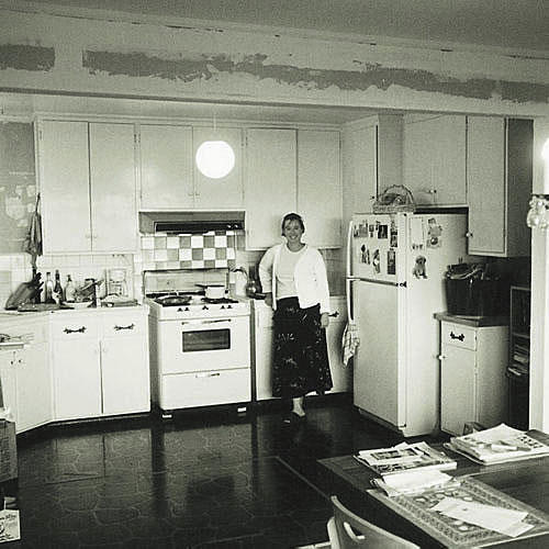 عتيق الطراز kitchen with plain white cabinets, dark floors and an old white stove