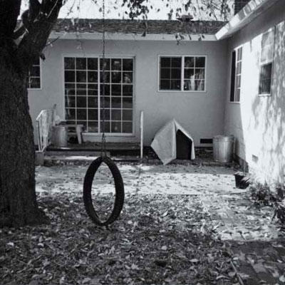 преди photo of a backyard with a tire swing and a large tree