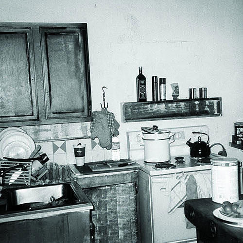 أصلي photo of an old kitchen in a beach shack with cramped space