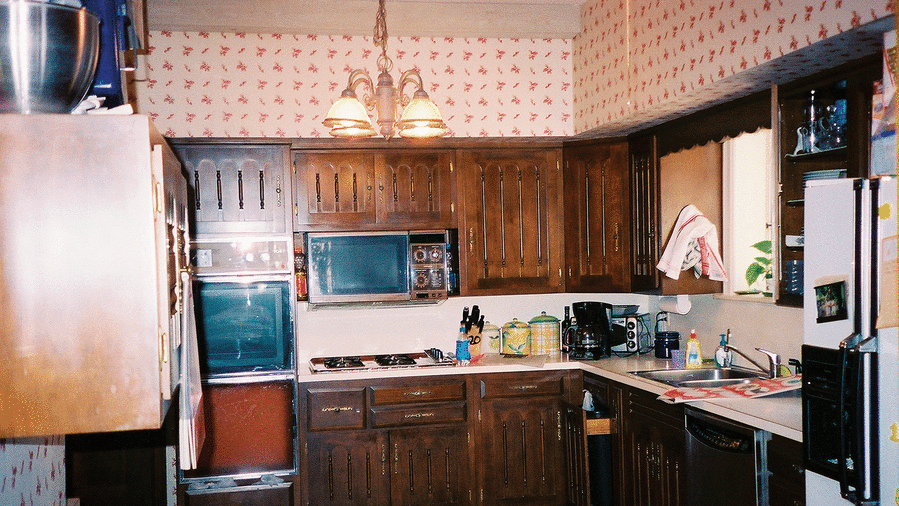 عتيق الطراز kitchen with dark wooden cabinets, red tile floors and old kitchen appliances