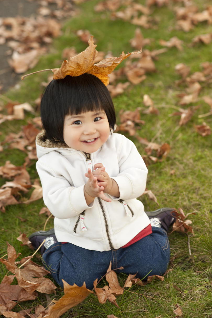 طفل صغير playing in fall leaves