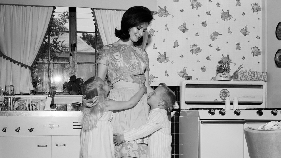 деца hugging mom in kitchen