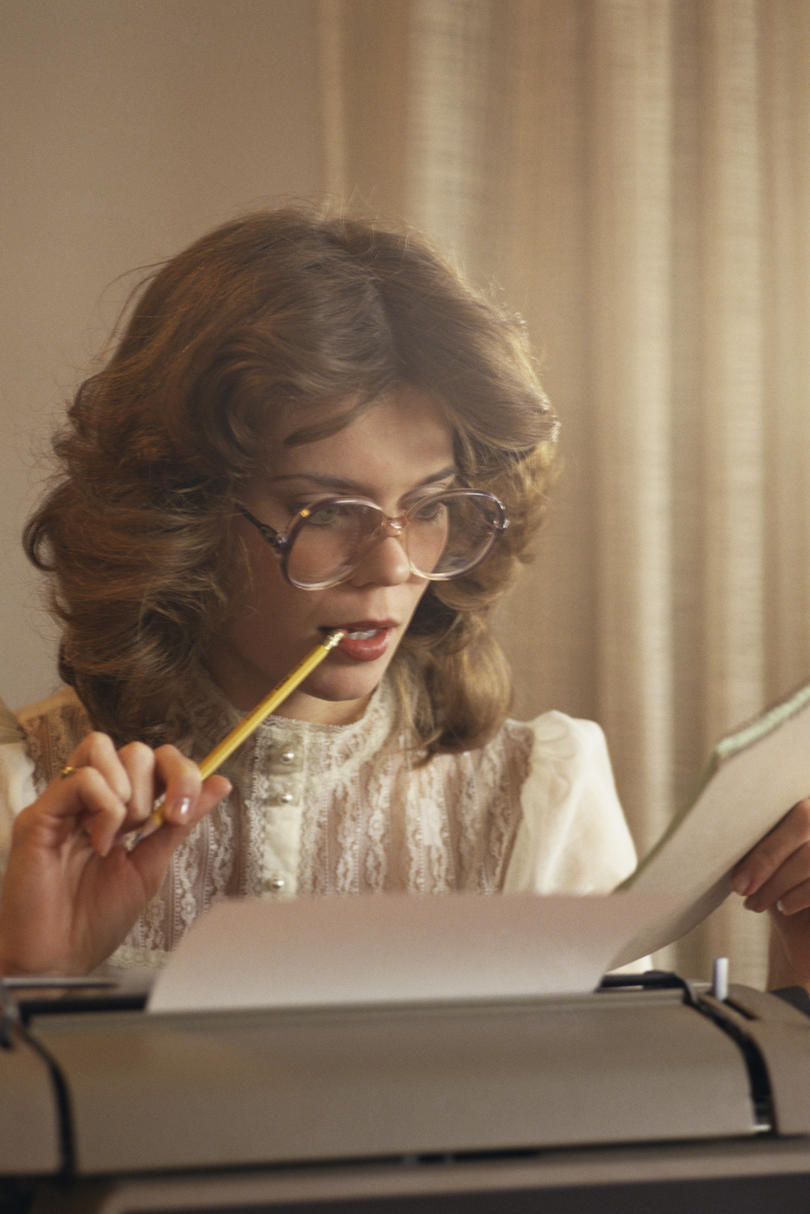 女性 working with typewriter