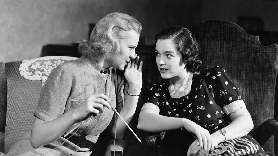 две women talking while knitting