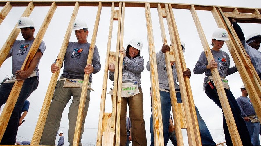 voluntarios putting up framing for house