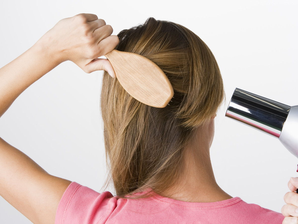 Mujer brushing and drying hair